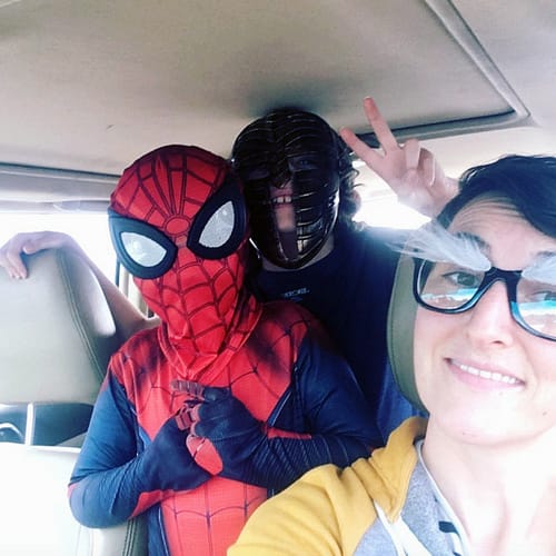 Bridgid in the car with her two kids dressed in costumes.